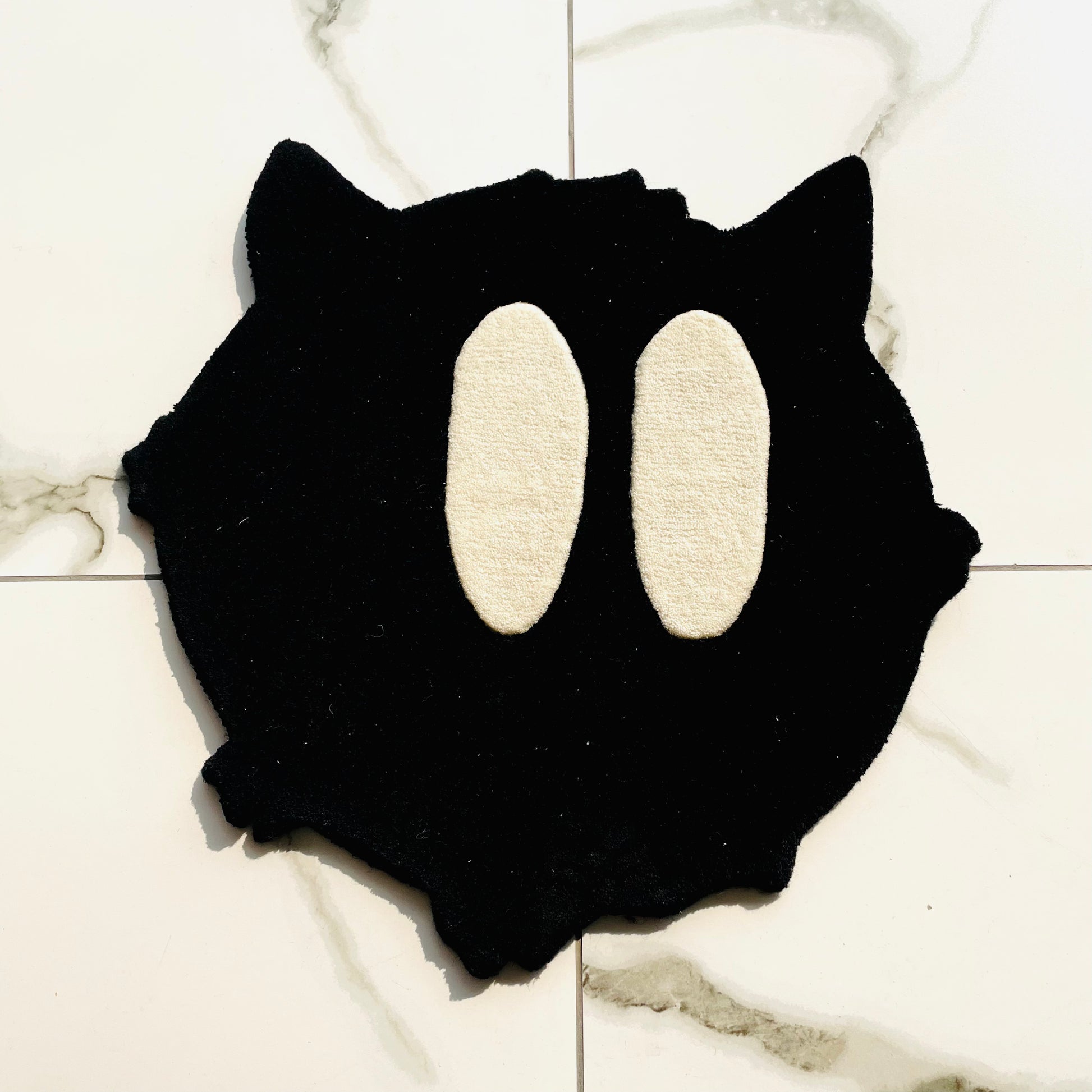 Black cat rug with big white eyes top view